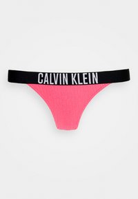 Růžové žebrované string kalhotky s černým elastickým pasem, na kterém je bílé nápis "CALVIN KLEIN". Zadní střih je minimální, což zajišťuje elegantní design.