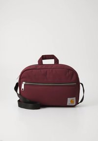 Rucsac din material maro roșcat, cu un buzunar frontal prevăzut cu fermoar, mâner superior și o curea de umăr neagră detașabilă. Are o etichetă cu logo pe lateral.