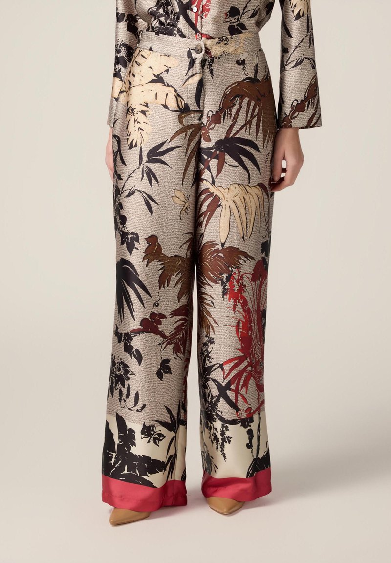 Blumenmusterweite Hosen aus strukturiertem Stoff, in den Farben Gold, Schwarz und Rot mit einem kontrastierenden roten Satinsaum.