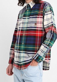 Camicia a maniche lunghe in plaid, caratterizzata da una combinazione di motivi a rombi rossi, blu, verdi e bianchi; in cotone; taschino sul petto con dettaglio del logo.