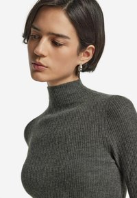 Grauer, gerippter Rollkragenpullover mit taillierter Passform und strukturiertem Stoff, der einen hohen Kragen und keine sichtbaren Verschlüsse oder Verzierungen aufweist.
