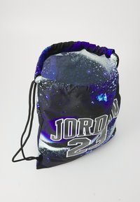Crna torba s reklamom na vezivanje s uzorkom galaksije, koja na prednjoj strani prikazuje "JORDAN 23" u velikim, metalik srebrnim slovima.
