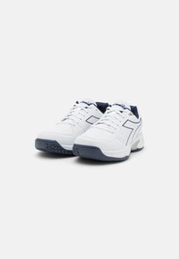 White athletic shoes with navy accents, perforated upper for breathability, textured rubber sole for grip, and laces for secure fit.