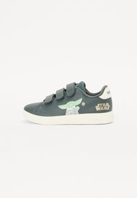 Vihreät synteettiset sneakersit, joissa on kaksi tarranauhaa, Yoda-grafiikka sivussa ja "STAR WARS" -logointi kullalla kantapäässä.