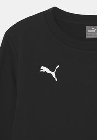 Sudadera negra con cuello redondo y puños de canalé, con un logo blanco de Puma en el pecho. El material parece suave y tiene una textura lisa.