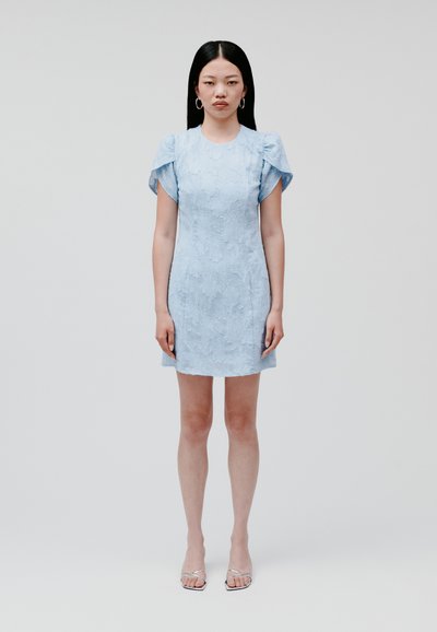 Himmelblaues, strukturiertes Minikleid mit Puffärmeln. Hat einen runden Halsausschnitt, eine taillierte Silhouette und wird mit silbernen, geschnürten Sandalen kombiniert.