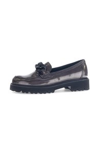 Glossy dark brown loafer with chunky black sole and large decorative knot detail on top, shown against a white background.