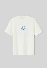 T-shirt blanc à manches courtes avec col rond, présentant un texte bleu Henri Matisse et un motif abstrait de feuille découpée au centre devant.