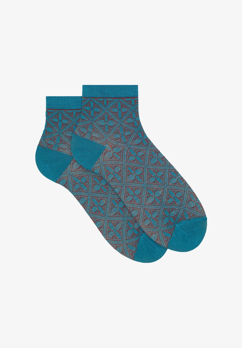 Calzini alla caviglia turchesi con un motivo geometrico e accenti rossi e blu navy, realizzati in un morbido tessuto testurizzato.