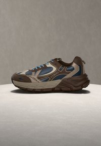 Baskets sportives avec des panneaux marron, beige et bleu, des lacets bleu clair, une semelle épaisse et le logo "ICEBERG 1974" sur le côté.