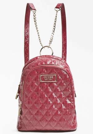 Lille blank rød quiltet rygsæk med præget mønster, guldfarvede lynlåse, kædedetalje og GUESS-logo på forsiden.