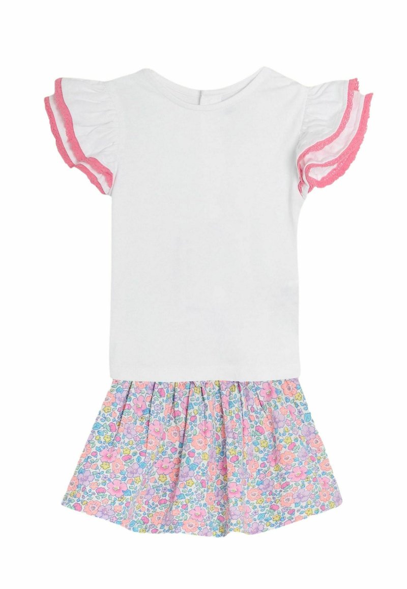 Balta medvilninė palaidinė su rožinėmis volanų rankovėmis, prisegta prie plačios sijono, puošto spalvingu gėlių raštu rožinės, violetinės ir žalios spalvų.