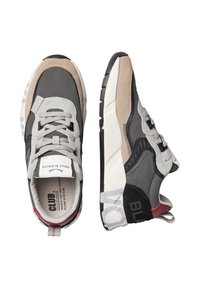 Baskets avec un mélange de matériaux gris, noirs et beiges, présentant un design à lacets, un col rembourré, des accents texturés et un détail de logo sur la semelle.