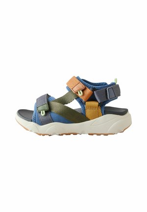 Des sandales sportives colorées avec des sangles bleues, vertes et brunes, des boucles réglables, un semelle rembourrée et une semelle en caoutchouc texturé.