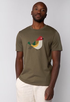 Olivegrünes Baumwoll-T-Shirt mit einem stilisierten Vogelgrafik in Rot, Gelb, Grün und Schwarz. Kurzärmlig mit Rundhalsausschnitt.