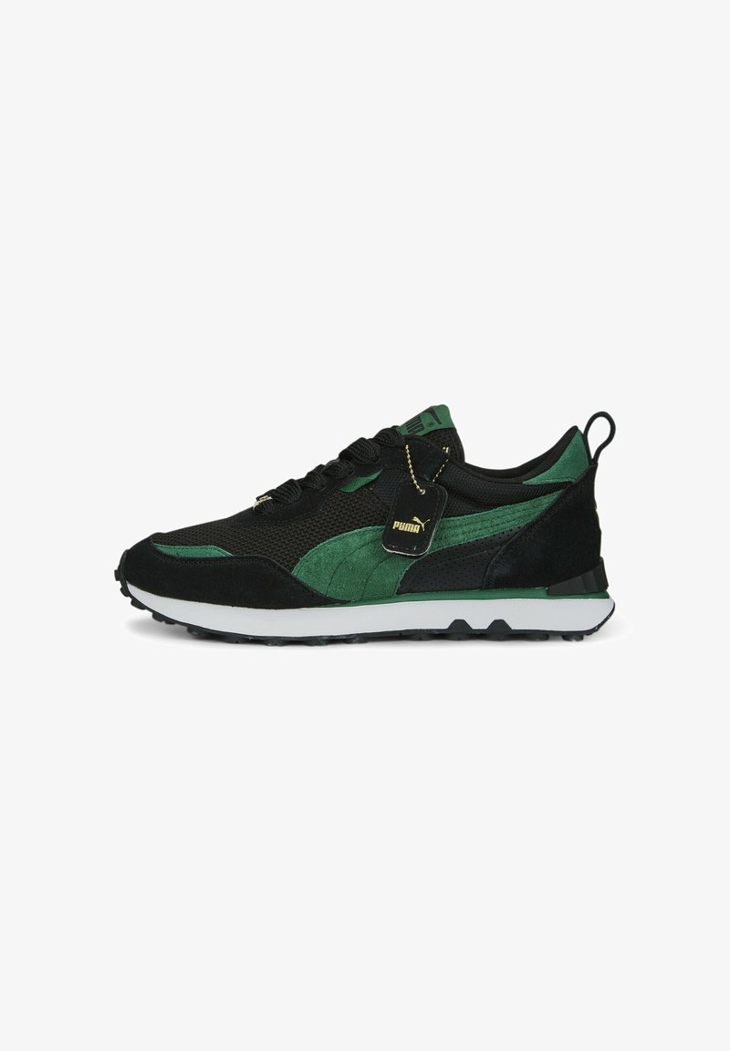 Baskets Puma noires et vertes avec dessus en mesh et en daim, semelle blanche, lacets noirs et étiquette avec logo Puma attachée près des lacets.
