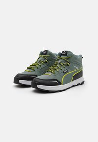 Green mid-top sneakers with black accents, yellow details, textured rubber soles, and patterned laces. Features PUMA logo on the tongue.