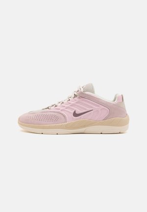 Lichtroze en beige Nike-sneaker met suède en mesh bovenwerk, vetersluiting en rubberen zool, zijaanzicht.