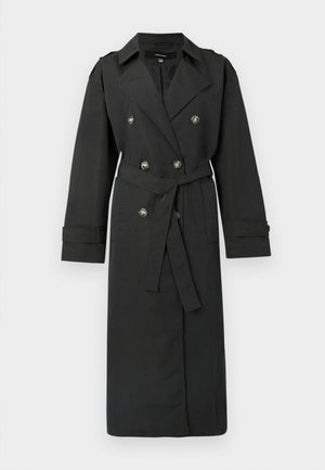 Svart trenchcoat med dobbeltradet design og sølvknapper, belte i midjen, og lange ermer med oppbrettede mansjetter. Klassisk slagkrage.