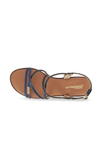Sandal in pelle marrone con cinturini intrecciati blu, fibbia regolabile alla caviglia, ampia area per le dita e dettagli del marchio sulla soletta. Finitura liscia in tutto.