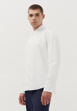 Witte lange mouwen shirt met een knoopsluiting aan de voorkant, standaard kraag en een gladde, katoenachtige textuur. Draag het met marineblauwe pantalon.
