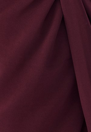 Bordeaux stof met een zachte, gladde textuur, gekenmerkt door lichte plooien en drapering. Geen zichtbare patronen of hardwaredetails.