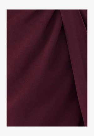 Bordeauxfarbener Stoff mit einer weichen, glatten Textur, der sanfte Falten und Drapierungen aufweist. Keine sichtbaren Muster oder Hardware-Details.