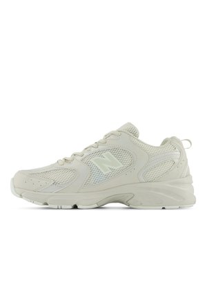 Chaussure de sport légère en crème avec tige en mesh, superpositions texturées, bout arrondi et semelle rembourrée ; comprend un système de laçage et un détail de logo.