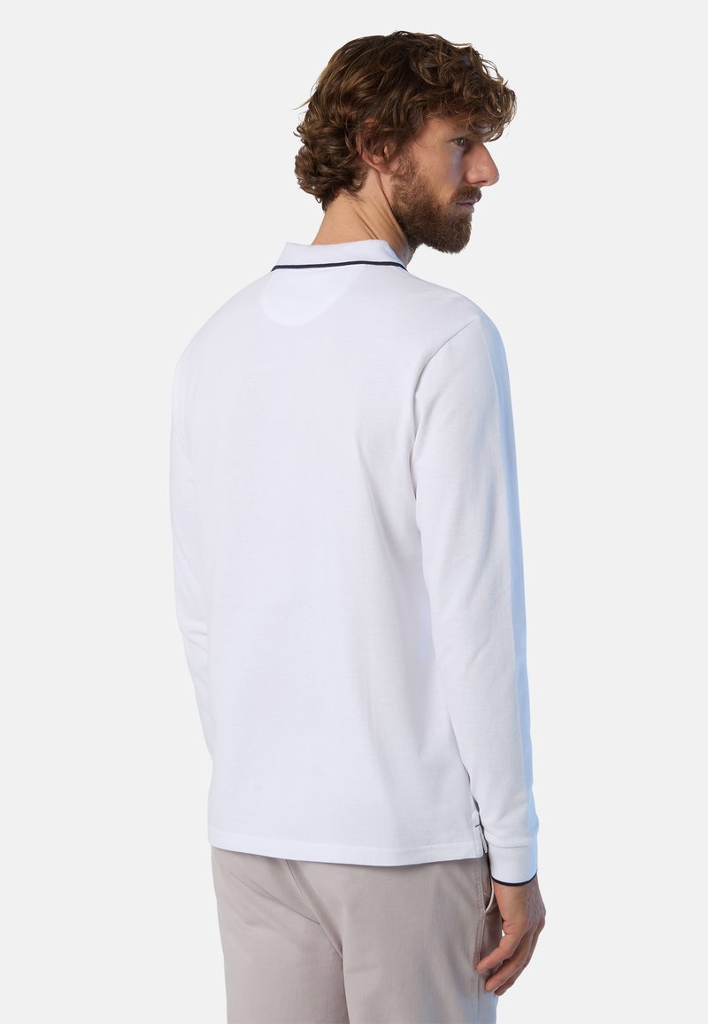 Camisa polo blanca de manga larga con ribete color navy en el cuello, hecha de material de algodón. Presenta un dobladillo recto y puños acanalados.