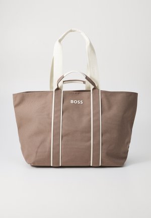 Bruine canvas tote bag met witte handvatten, met het woord "BOSS" op de voorkant. Ontworpen met drie strepen langs de zijkanten.