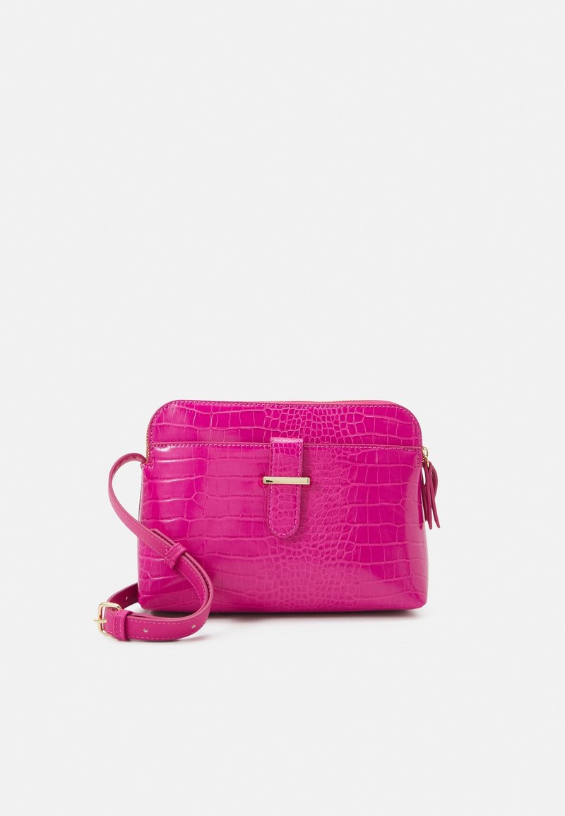 Różowa torebka na ramię z imitacji skóry krokodyla, z zamkiem błyskawicznym, płaskim paskiem i małym ozdobnym chwostem. Złote elementy ozdobne.