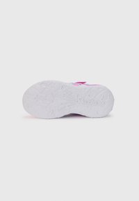 Suela de goma texturizada blanca con patrón de estrellas; acentos coloridos en rosa, morado y aqua en la parte superior, con correas de doble gancho y bucle.