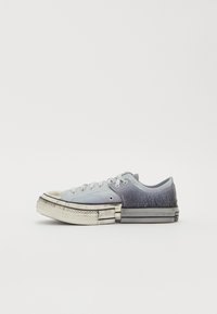 Graue Leinen-Sneaker mit Gummi-Zehenkappe, strukturierten Akzenten und geschichteter Sohle. Abgenutzte Optik mit kontrastierenden Farbtönen und klassischer Schnürung.