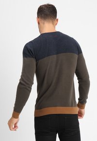 Herrtröja med blockfärgsdesign i marinblått, olivgrönt och brunt. Stickat tyg med ribbade muddar och fåll.