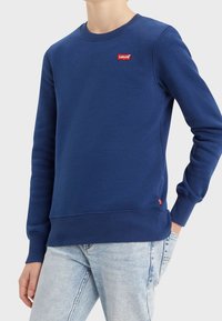 Felpa blu navy in misto cotone con scollatura a girocollo, polsini e orlo a costine, caratterizzata da un piccolo logo rosso Levi's sul petto.