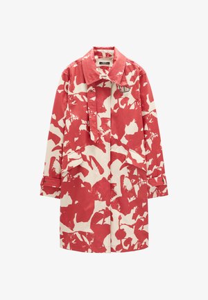 Długi płaszcz z czerwonym i kremowym abstrakcyjnym kwiatowym wzorem, kołnierzem, przednimi kieszeniami oraz detalami klamry na pasku przy szyi i mankietach.