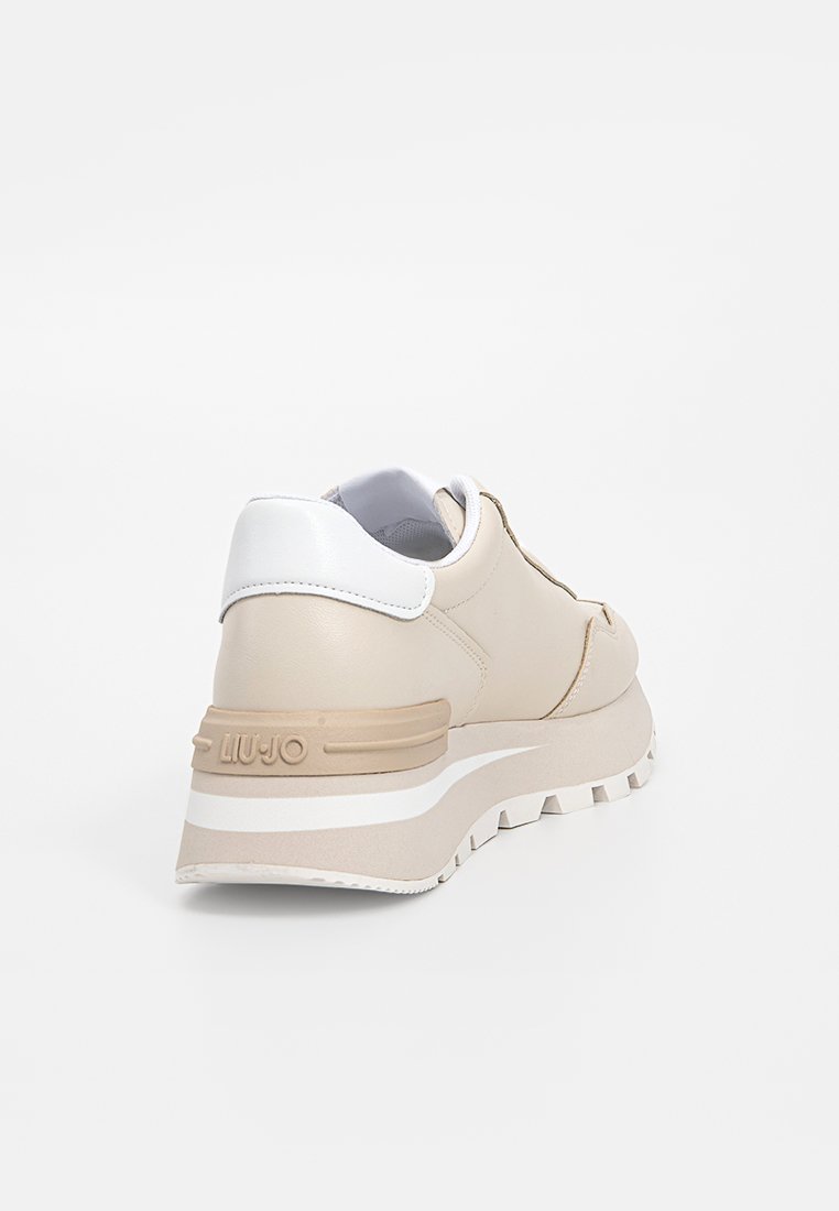 Zapatillas de piel beige con acentos blancos, una suela de plataforma gruesa y un acabado texturizado. Cuenta con un sutil logo en la parte trasera.
