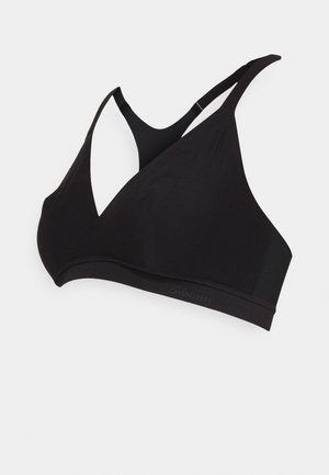 Black wireless bra made of smooth fabric, featuring a crisscross back design, no padding, and an elastic waistband with branding detail.
