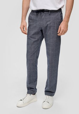Herren-Hosen in Marineblau mit Muster und kariertem Design, elastischem Bund mit Zugband und seitlichen Taschen. Kombiniert mit weißen Sneakers.