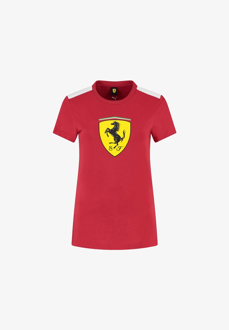 Czerwona koszulka z krótkim rękawem wykonana z bawełny. Posiada czarne logo Ferrari na żółtej tarczy oraz białe akcenty na ramionach.