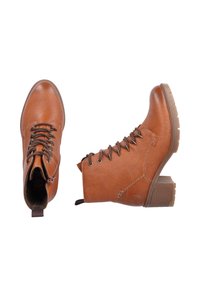 Bottines en cuir brun avec un bout rond, fermeture à lacets à l'avant et semelle en caoutchouc épaisse. Caractéristiques de détails de couture et un léger talon.