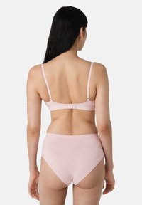 Svetle růžový kompletní překrásné spodní prádlo obsahující podprsenku s nastavovacími ramínky a háčkovým zapínáním, doplněnou o kalhotky s vysokým pasem, z jemného a hladkého materiálu.