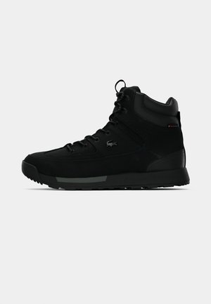Black high-top sneaker with lace-up front, padded collar, and rubber sole, featuring a small textured logo on the side.