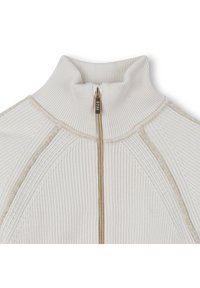 Λευκό πλεκτό πουλόβερ με ψηλό γιακά και χρυσό φερμουάρ. Διαθέτει υφασμάτινες ρίγες κατά μήκος των ώμων και διακριτικές χρυσές λεπτομέρειες.