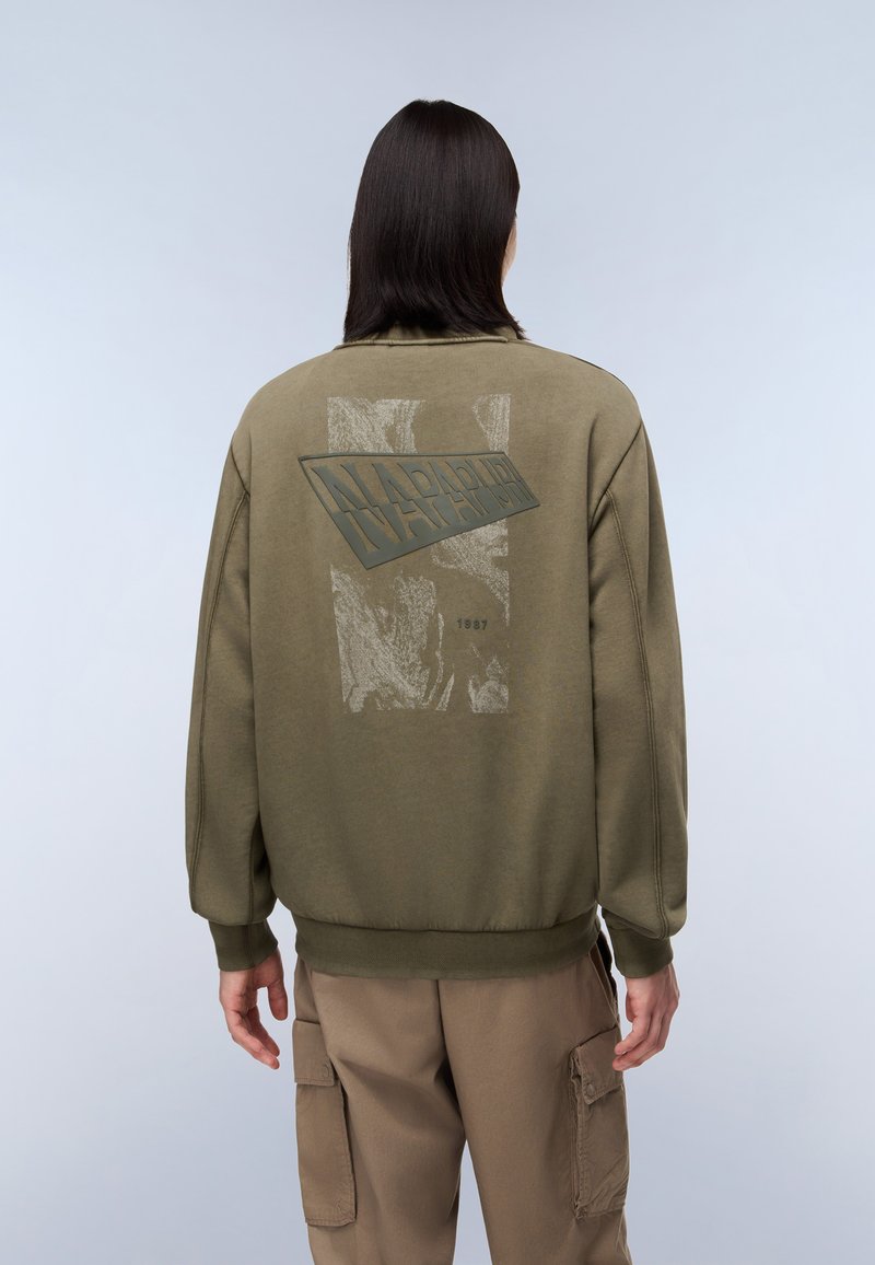 Oliven grøn sweatshirt med et tekstureret grafisk print på bagsiden, der viser et rektangulært logo og året "1987." Behagelig pasform og ribbede manchetter.