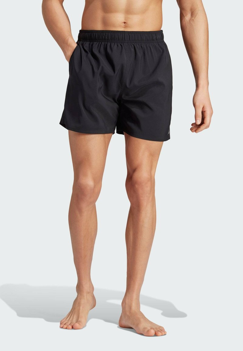 Black swim shorts with an elastic waistband, side pockets, and a smooth texture. Designed for comfort and ease of movement.