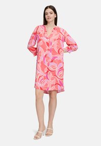 Rosa Blumenkleid mit V-Ausschnitt, Dreiviertelärmeln und einer lässigen Passform. Es zeigt abstrakte Rosenmuster in Schattierungen von Rosa und Lila.