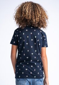 Camiseta de algodón azul marino de manga corta, con un patrón repetido de iconos coloridos, incluyendo estrellas y varios recipientes.