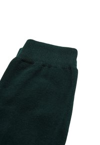 Corte de calcetín de punto verde oscuro con textura acanalada y una banda de goma suave y elástica, mostrando un tejido liso sin patrones ni acentos.