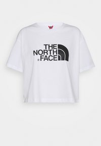 Bílý krátký bavlněný tričko s velkým černým logem "THE NORTH FACE" na hrudi, krátkými rukávy a kulatým výstřihem.